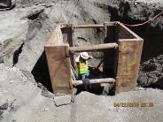 A construction worker is seen here in a trench box. A trench box is required for any depth over 4', due to the danger of the hol