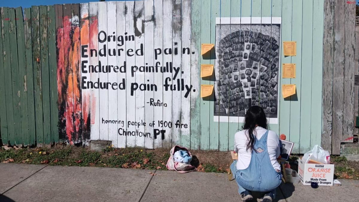 Poet Laureate Rufina C. Garay with her piece on for the Outsiders Street Art Project on the Memorial Field Fence